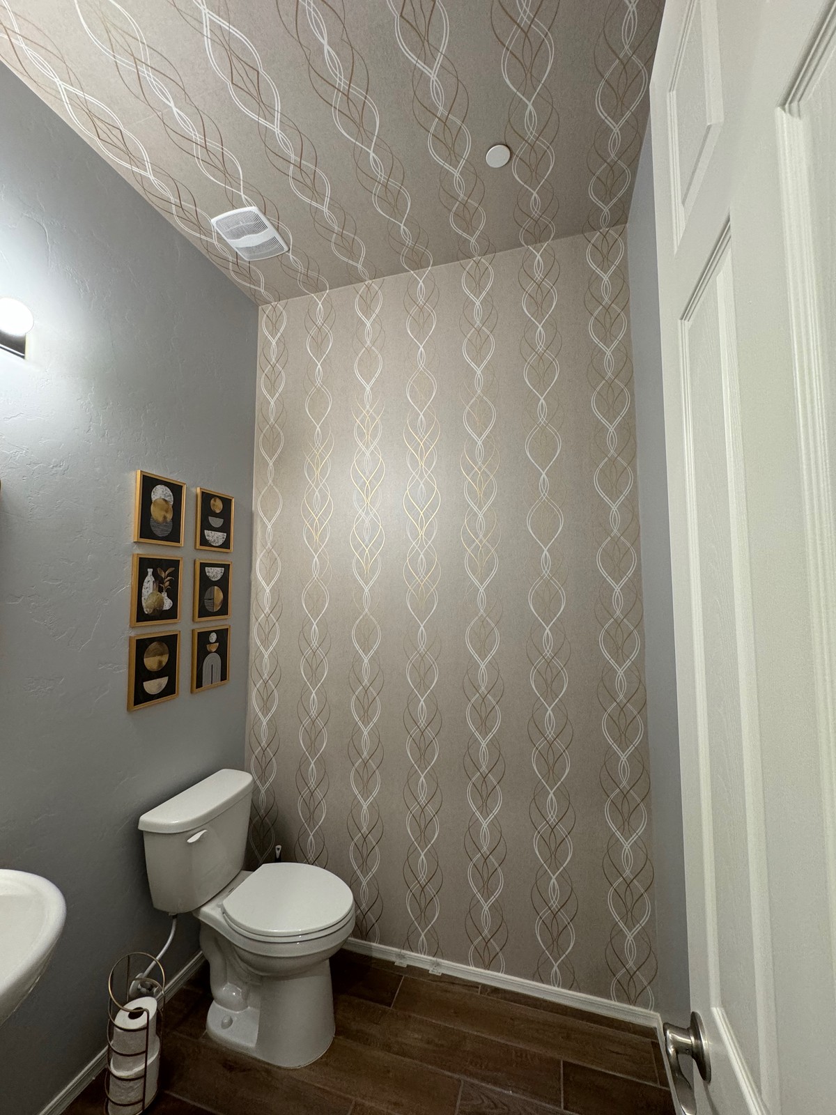 Completed bathroom with mirrored pattern wallcovering on walls and ceiling